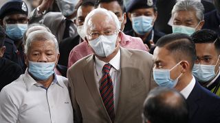 Former Malaysian Prime Minister Najib Razak, center, wearing a face mask with his supporters arrives at courthouse in Kuala Lumpur, Malaysia, Tuesday, July 28, 2020.