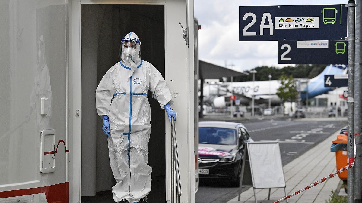 Le personnel médical attend que les voyageurs passent les tests du COVID-19 à leur arrivée à l'aéroport de Cologne, en Allemagne, le mardi 28 juillet 2020