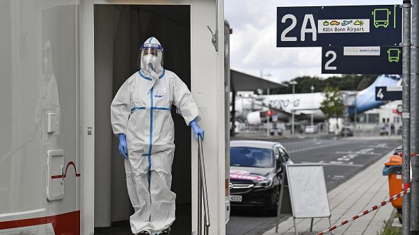 Le personnel médical attend que les voyageurs passent les tests du COVID-19 à leur arrivée à l'aéroport de Cologne, en Allemagne, le mardi 28 juillet 2020 Le personnel médical attend que les voyageurs passent les tests du COVID-19 à leur arrivée à l'aéroport de Cologne, en Allemagne, le mardi 28 juillet 2020