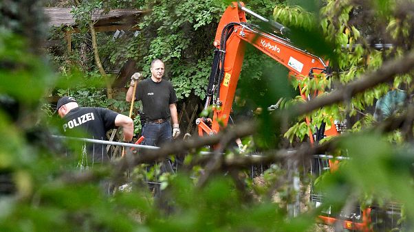 La polizia tedesca perquisisce un giardino a Seelze, vicino ad Hannover, Germania La polizia tedesca perquisisce un giardino a Seelze, vicino ad Hannover, Germania