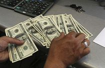 A currency exchange bureau worker, counts US dollars, in downtown Tehran, Iran