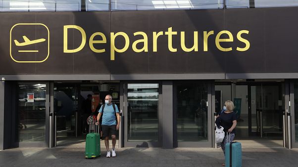 Passengers walk out of Departures, at the North Terminal of Gatwick Airport near Crawley, just south of London, Wednesday, July 22, 2020. 