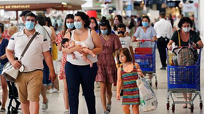 Customers wear face masks as they shop in a shopping mall in Anglet, southwestern France.