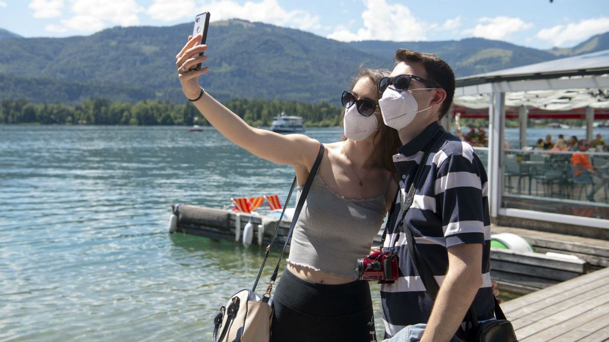 A couple make selfies at the lake side in St. Wolfgang, Austria