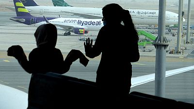 I passeggeri osservano gli aerei in pista, mentre aspettano il loro volo all'aeroporto internazionale di Gedda, Arabia Saudita