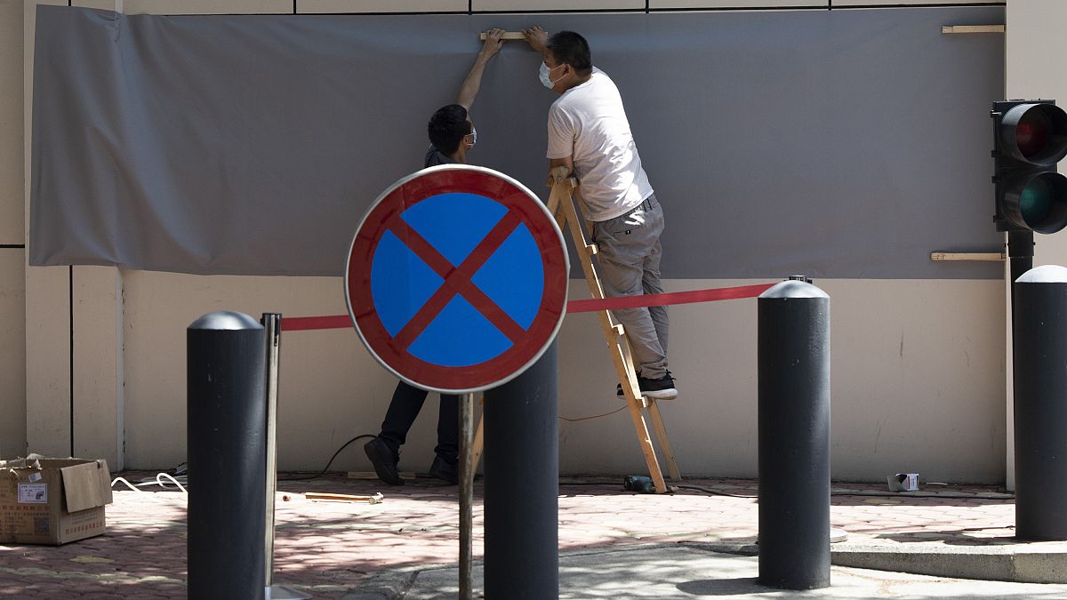 العمال يستعدون لتغطية المناطق التي كانت تستخدم فيها اللافتات لإظهار الموقع كقنصلية للولايات المتحدة في تشنغدو بمقاطعة سيتشوان جنوب  غرب الصين غرب الصين . 