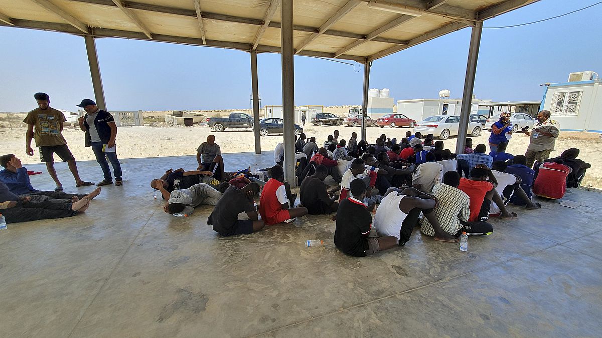 In this file photo from 2019, rescued migrants rest near the city of Khoms, around 120 kilometres east of Tripoli.