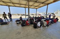 In this file photo from 2019, rescued migrants rest near the city of Khoms, around 120 kilometres east of Tripoli.