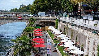 People enjoy the sun on deckchairs along the river Seine in Paris, Tuesday, July 28, 2020.