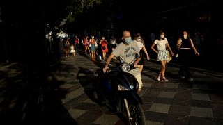 Personas con mascarillas para prevenir la propagación del coronavirus, caminan por una calle de Madrid, España, el  28 de julio de 2020.