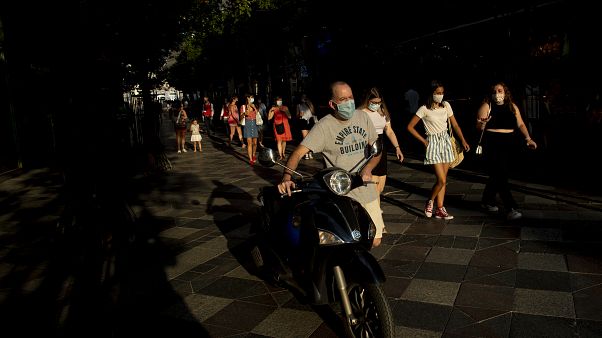 Personas con mascarillas para prevenir la propagación del coronavirus, caminan por una calle de Madrid, España, el 28 de julio de 2020. Personas con mascarillas para prevenir la propagación del coronavirus, caminan por una calle de Madrid, España, el 28 de julio de 2020.