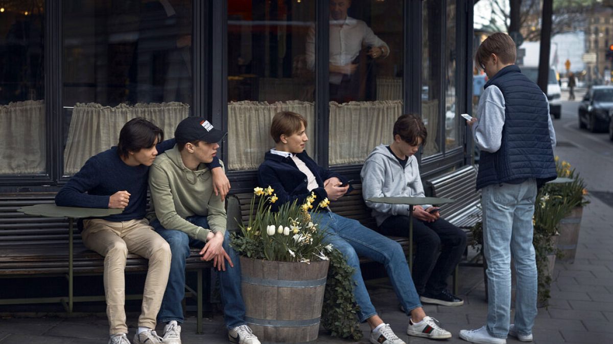 Youth hang out outside a restaurant in Stockholm, Sweden, Wednesday, April 8, 2020