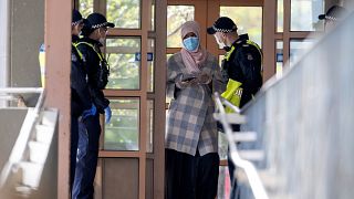 Police talk to a woman at housing commission apartments under lockdown in Melbourne, Australia, on Monday, July 6, 2020. 