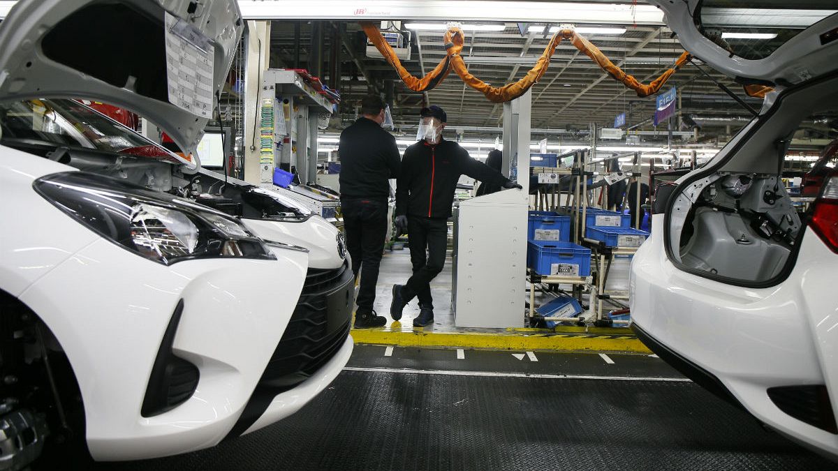 Employee wearing a face masks stand by the production chain of the Yaris car at the Toyota car factory in Onnaing, northern France