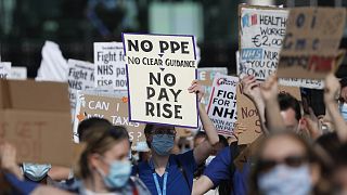 Demonstrators, a number of them nurses and care workers from St Thomas' Hospital, hold placards as they protest for a pay rise in London on 29 July.