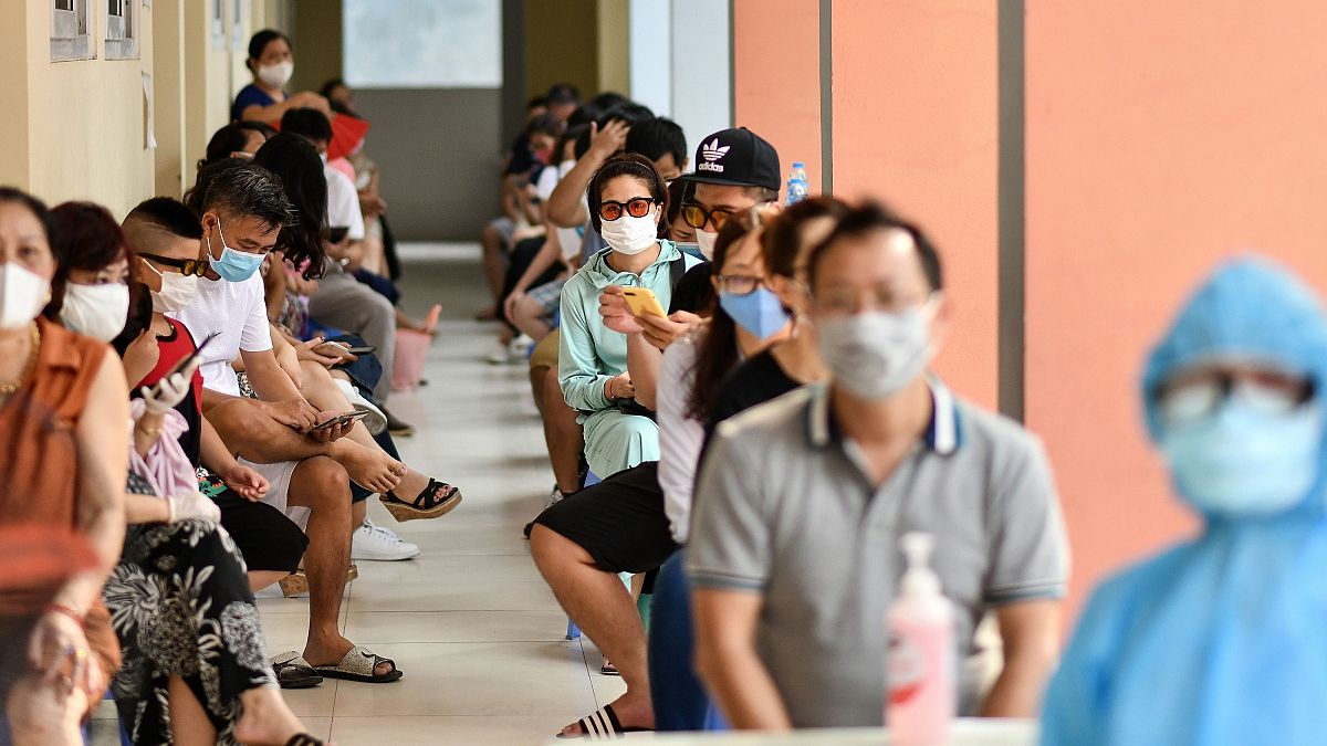 Residents wait to be tested at a centre as Vietnam records a rise in COVID-19 cases