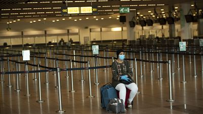 A woman sits at the almost empty departures hall at the Zaventem international airport in Brussels, Wednesday, July 29, 2020. A woman sits at the almost empty departures hall at the Zaventem international airport in Brussels, Wednesday, July 29, 2020.