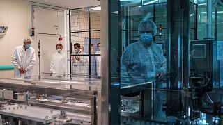 In this June 16, 2020, file photo, French President Emmanuel Macron listens to a researcher as he visits an industrial development laboratory  at Sanofi Pasteur plant ,