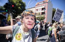 Una mujer lleva una máscara de Angela Merkel con la inscripción "adíos democracia" en la manifestación contra las restricciones en Berlín, Alemania, el 1 de agosto, 2020.