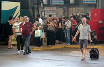 People boarding buses in Greece