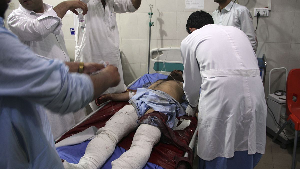 A wounded man receives treatment at a hospital after a suicide car bomb and multiple gunmen attack in the city of Jalalabad, east of Kabul, Afghanistan, Sunday, Aug. 2, 2020.