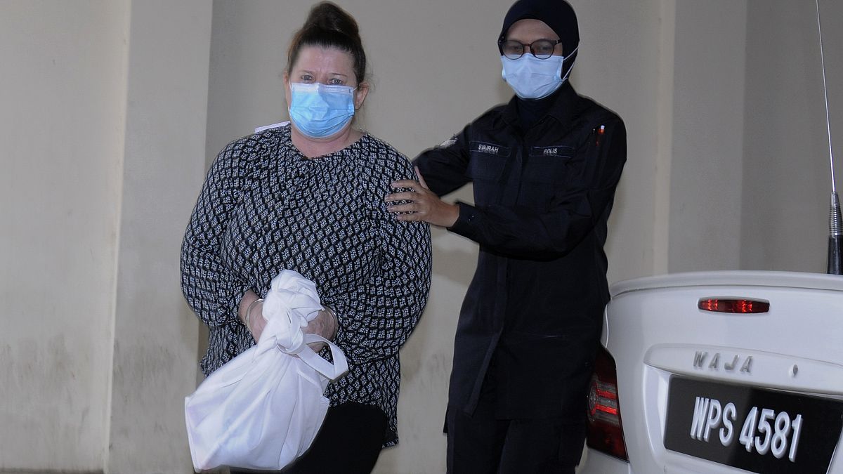 British woman Samantha Jones, left, is escorted by police as she arrives at Alor Setar's courthouse, Kedah state, Malaysia, Monday, Aug. 3, 2020. 