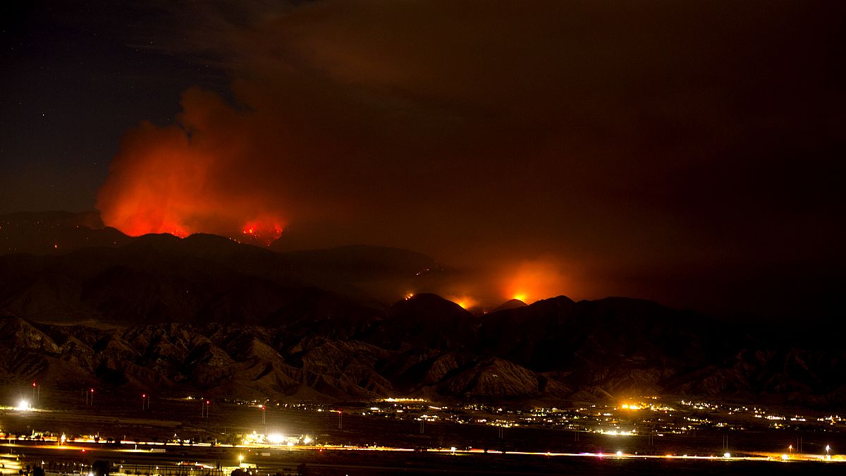 The Apple Fire burns behind mountains near Beaumont, California, Sunday, August 2, 2020.