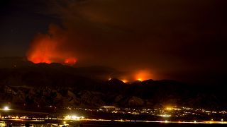 The Apple Fire burns behind mountains near Beaumont, California, Sunday, August 2, 2020.