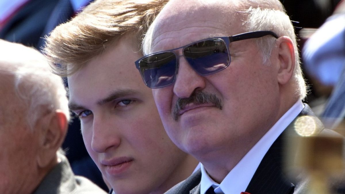 This handout picture provided by Host photo agency shows Belarus's President Alexander Lukashenko and his son Nikolai watching a military parade