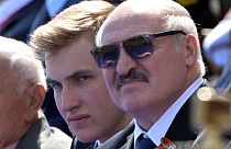 This handout picture provided by Host photo agency shows Belarus's President Alexander Lukashenko and his son Nikolai watching a military parade