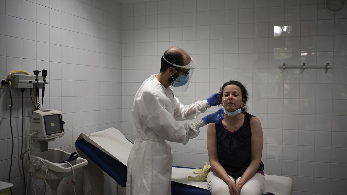 شابة تجري اختبار تحليل الإصابة بمرض كوفيد-19 في مركز الرعاية الصحية الأولية في منطقة كاتالونيا في إسبانيا.