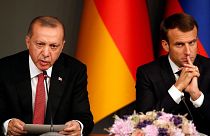 Turkey's President Recep Tayyip Erdogan, left, sits by French President Emmanuel Macron during a news conference following a summit on Syria, in Istanbul, Saturday, Oct. 27, 2