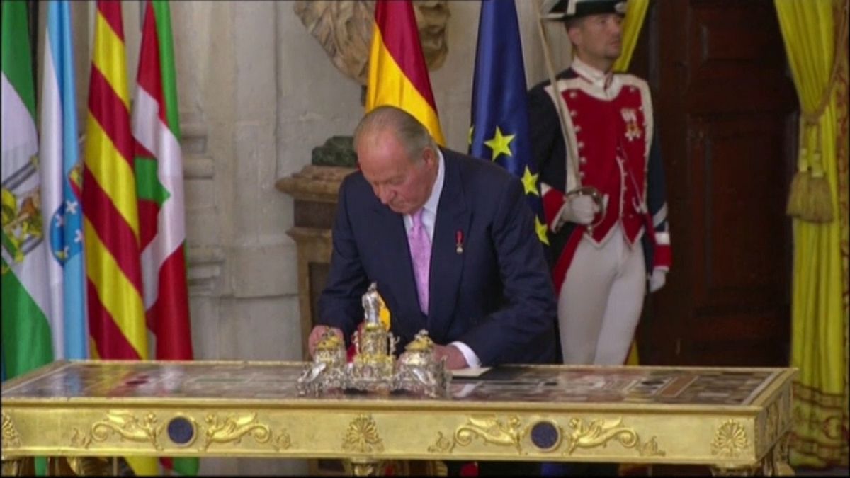 El rey emérito Juan Carlos I firmando su abdicación en 2014