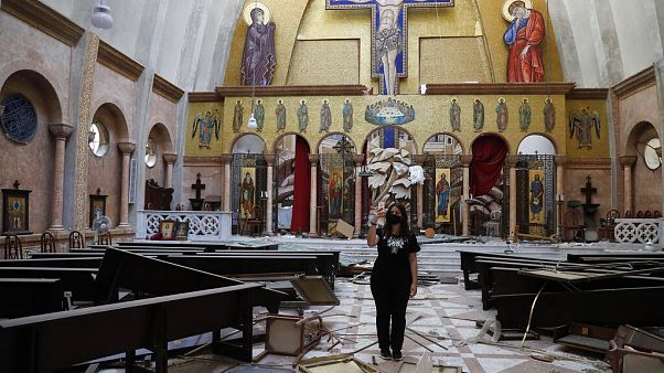 Nő készít képeket egy megsérült keresztény templomban szerdán Nő készít képeket egy megsérült keresztény templomban szerdán