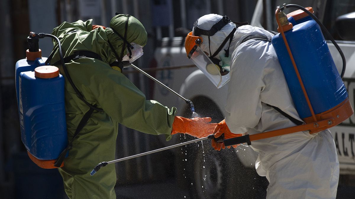 Des agents de plus grand hôpital de La Paz, en Bolivie, se désinfectant après être intervenus dans la morgue de l'établissement, le 5 août 2020   