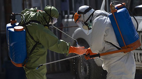 Des agents de plus grand hôpital de La Paz, en Bolivie, se désinfectant après être intervenus dans la morgue de l'établissement, le 5 août 2020 Des agents de plus grand hôpital de La Paz, en Bolivie, se désinfectant après être intervenus dans la morgue de l'établissement, le 5 août 2020