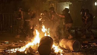 Riot police advance to push back anti-government protesters in Beirut on Thursday.