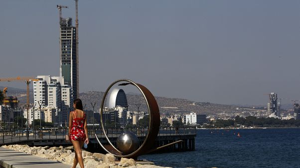 A woman walks across the sea in southern coastal city of Limassol, Cyprus A woman walks across the sea in southern coastal city of Limassol, Cyprus