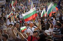 Protesters carry Bulgarian flags during mass protest in downtown Sofia, Bulgaria, on Wednesday, July 29, 2020.