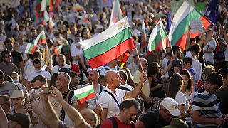 Protesters carry Bulgarian flags during mass protest in downtown Sofia, Bulgaria, on Wednesday, July 29, 2020.