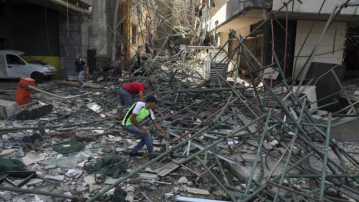 Workers remove rubble from damaged buildings near the site of an explosion on Tuesday that hit the seaport of Beirut, Lebanon, Thursday, Aug. 6, 2020.