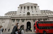 In this Wednesday, March 11, 2020 file photo, pedestrians wearing face masks pass the Bank of England in London.
