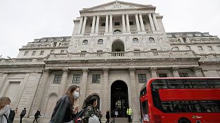 In this Wednesday, March 11, 2020 file photo, pedestrians wearing face masks pass the Bank of England in London.