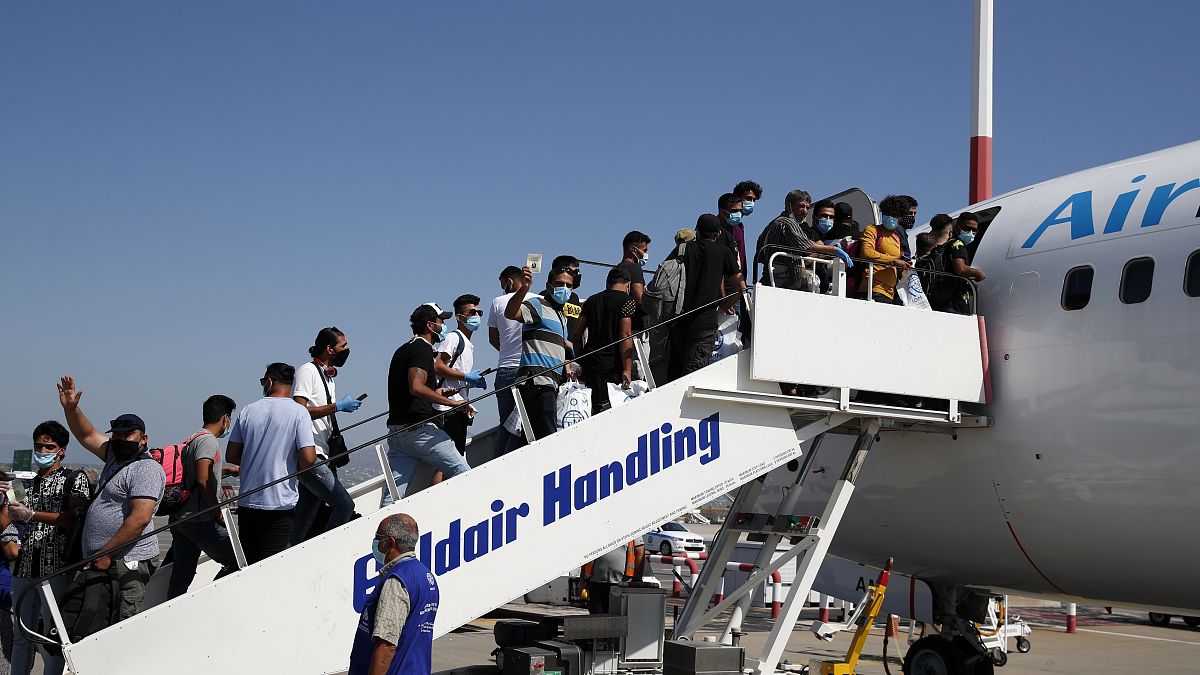 مهاجرون على متن طائرة متجهة إلى العراق في مطار الفثيريوس فينيزيلوس الدولي في أثينا 