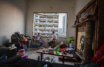 Dos libaneses fuman una pipa de agua en su apartamento destrozado del barrio de Gemmayzeh