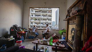 Dos libaneses fuman una pipa de agua en su apartamento destrozado del barrio de Gemmayzeh