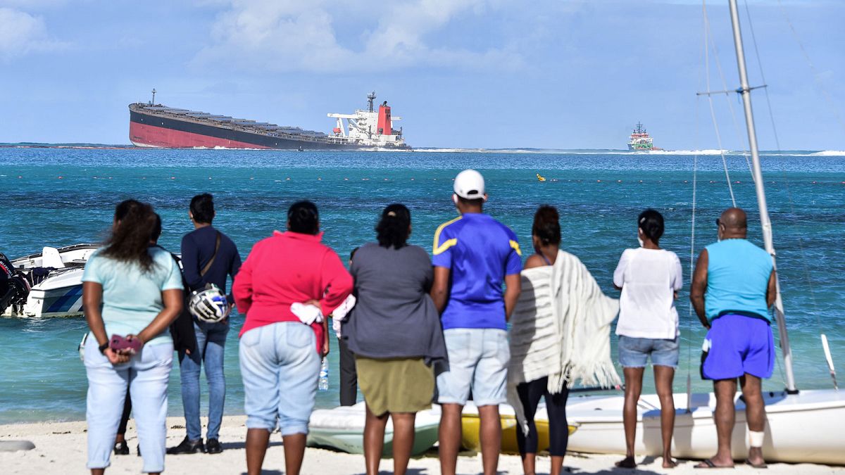 Des habitants de l'Île Maurice regardant le Wakashio d'où s'échappent des hydrocarbures, le 6 août 2020
