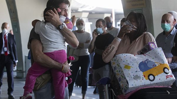 Sandro Manzato, from the Veneto region, hugs his daughter Yearline, 3, as she arrives with her mum Rubiela Perea, right, from Colombia, in Rome, June 3, 2020. Sandro Manzato, from the Veneto region, hugs his daughter Yearline, 3, as she arrives with her mum Rubiela Perea, right, from Colombia, in Rome, June 3, 2020.