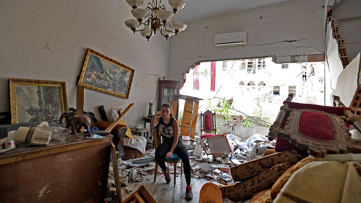 A woman sits among the rubble in her damaged house in the Lebanese capital Beirut on August 6, 2020, after a massive explosion shook the city