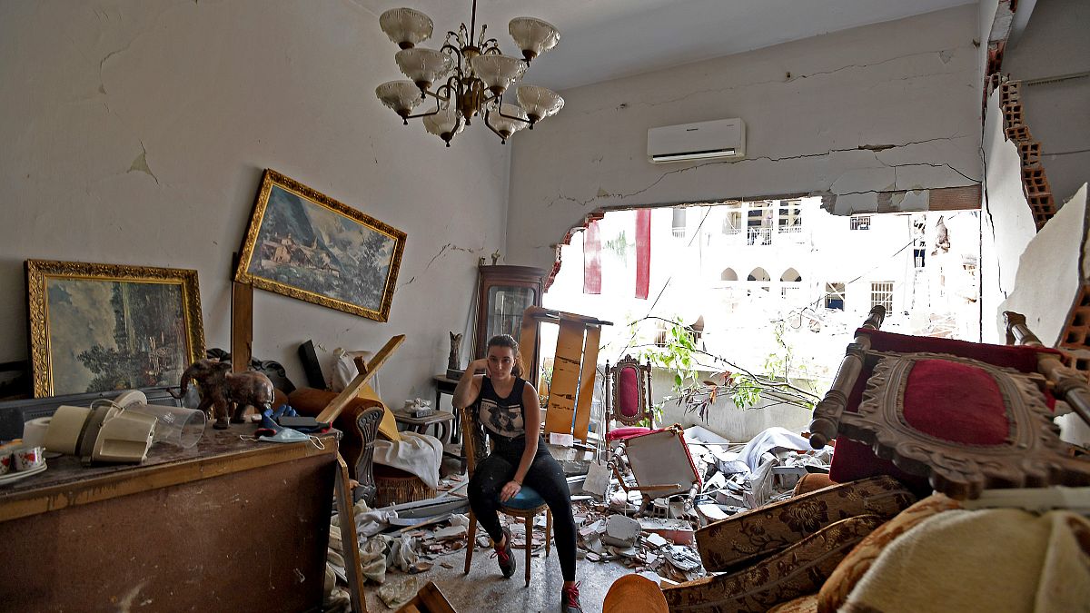 Une femme se tient assise au milieu de sa maison dévastée par l'explosion dans le port de Beyrouth, le 6 août 2020